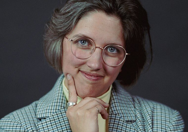 Mature businesswoman with glasses, hand to chin, thinking about her exit from the business. Photo by Abigail Boone on Unsplash